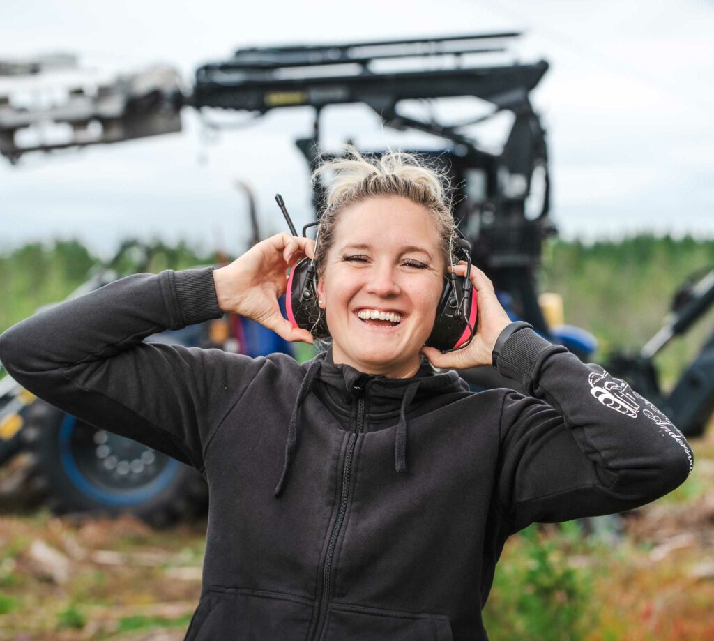 woman smiling in front of an excavator in sweden