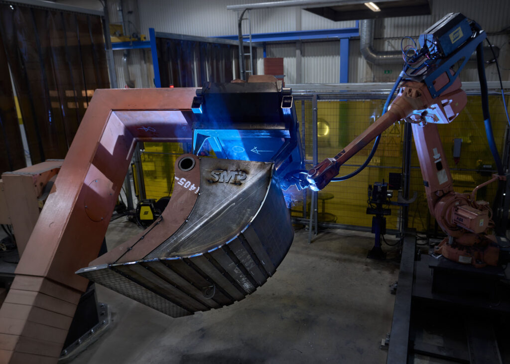 Robots welding on an excavator bucket