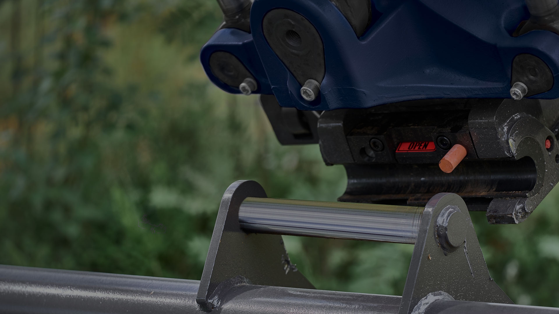 Quick coupler and excavator bucket outdoors just about to attach