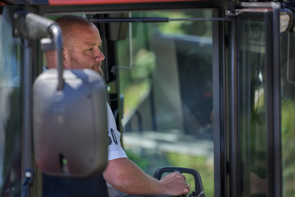 Man in a white shirt operating his excavator using a joystick