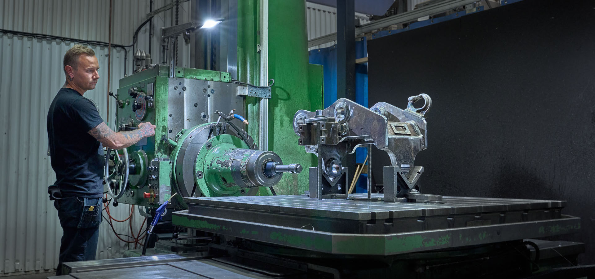 producting facility where a man is drilling in a quick coupler for excavators