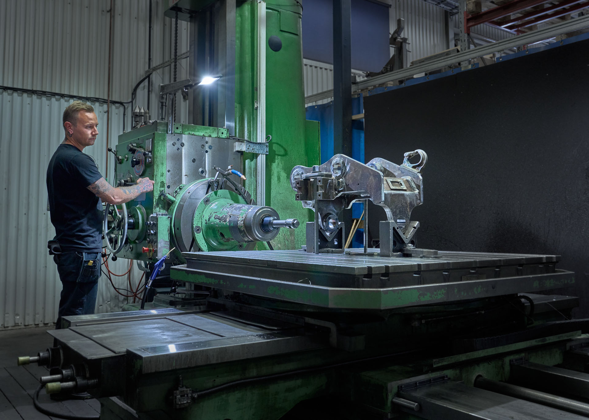 Swedish man at production facility making adjustments to an excavator