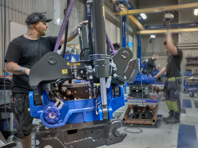 Three men in Sweden doing some work on tiltrotators in the manufacturing area