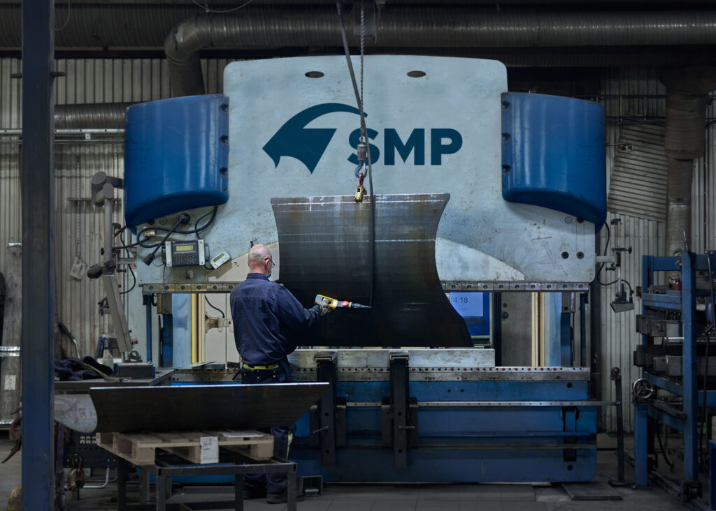 Man performing tests on an excavator bucket in SMP facilities in Ilsbo, Sweden